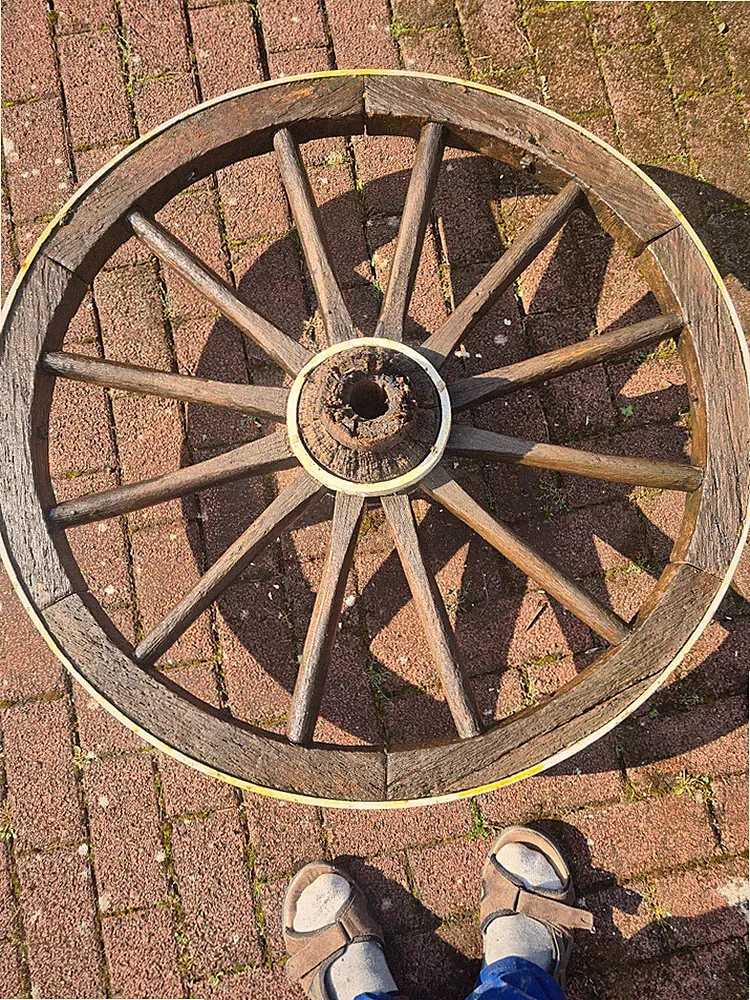 Wagenrad mit Glasplatte als Tisch im Garten
